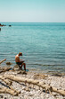 mężczyzna czytający ksiązkę naplaży w słońcu, Czarnogóra, Bigovica, Morze Adriatyckie, Adriatyk, morze, lazurowa woda, wakacje, zatoka