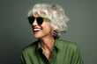 © Viktoria - Joyful Woman Laughing and Having Fun in Vibrant Green Outfit and Classic Glasses