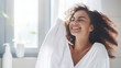 portrait of a smiling, relaxed woman in bathroom with a white towel