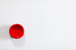 red color paint in a glass can on white surface