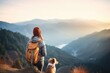 Tourist with a dog on a mountain peak