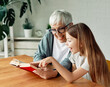 © Lumos sp - grandchild family child grandparent grandmother book reading elderly granddaughter girl  happy together read learning education woman