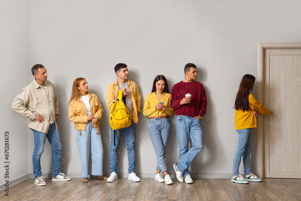 People standing in line near light wall