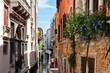 © Renata - Scenic canal with bridge and old buildings with potted plants in Venice, Italy