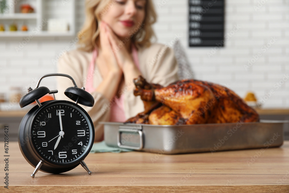 Stylish alarm clock on table in kitchen. Thanksgiving day celebration