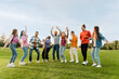 © Maria Vitkovska - Big group of happy stylish multiracial friends wearing colorful clothing dancing on corporate party in park. Diversity, friendship, positive lifestyle  concept