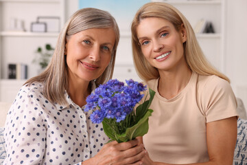 Sticker - Happy mature mother and her daughter with beautiful cornflowers at home