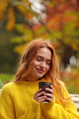 Poster - Portrait of beautiful woman with paper cup enjoying autumn outdoors