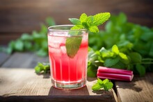 Homemade Rhubarb Lemonade In A Glass Jar With A Straw And Mint Leaves On A Sunlit Wooden Table