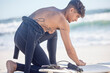 Fitness, beach and surfboard waxing of a man surfer ready for exercise, sport and training outdoor. Waves, ocean and summer workout of a young person with sport equipment in nature for surfing