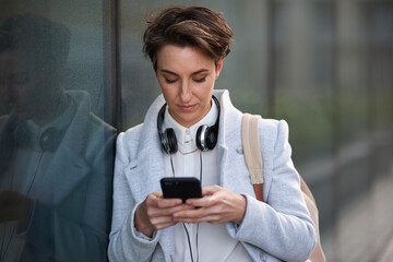 Wall Mural - woman, phone and social media with communication outdoor, chat or email with headphones, travel to w