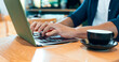 © HockleyMedia/peopleimages.com - Hands typing, computer and coffee shop for remote work, online research and planning for marketing project. Person, customer or freelancer at cafe or restaurant with internet, laptop and copywriting