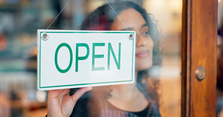 Canvas Print - Woman, small business or open sign on window in coffee shop or restaurant for service or advertising. Ready, start or entrepreneur holding board, poster or welcome for message in retail store or cafe