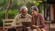 © PRASANNAPIX - indian senior couple sitting at park and using tablet