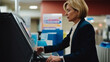© kalafoto - A person uses a self-checkout device in a supermarket