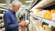 © kalafoto - A man is shopping for cheese in a supermarket
