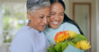 Hug, love and mother and daughter with flowers in home for bonding, relationship and smile together. Family, happy and mature mom embrace adult woman for mothers day, support and care in living room
