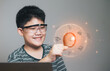 Asian boy holding the magnifying glass search internet modern technology concept, learning for technology, science, and education, studying or inspection project research
