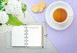 Top view of text Things to do checklist on notepad with pencil and tea cup on table, office desk. Smart goal setting with notebook, snack, tea, white flowers on the table.