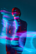 Silhouette of young woman standing against blue background with mixed neon lights effect. Hologram. Concept of modern art, beauty, style, futurism and cyberpunk, creativity