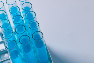 Poster - Close up of laboratory test tubes with blue liquid and copy space on white background