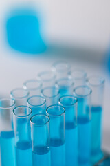 Poster - Vertical image of laboratory test tubes with blue liquid and copy space on white background