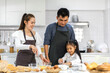 © Art_Photo - Portrait of enjoy happy love asian family father and mother with little asian girl daughter child play and having fun cooking food together with baking cookie and cake ingredient in kitchen