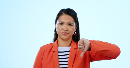 Sticker - Portrait, woman and thumbs down with rejection, no and feedback on a blue studio background. Face, girl and model with facial expression, hand gesture and review with complaint, opinion and decision