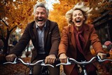 Szczęśliwa para starszych ludzi jadąca na rowerze po parku jesienią. 