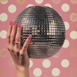 © ratatosk - Creative contemporary collage of woman hand holding disco ball on pink background. Concept of celebration, music, event in 80s and 90s retro style. Trendy vintage party symbol. Creative Christmas card