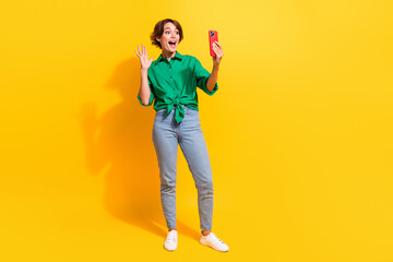 Poster - Full length photo of cute excited lady wear green shirt waving arm recording video vlog empty space isolated yellow color background