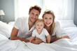 © Irina - a Happy Family with a newborn baby, lying on a light bed in a very bright room
