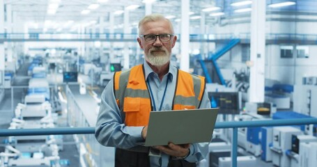 Poster - Portrait of a Handsome Middle Aged Engineer Wearing Glasses, Using Laptop Computer and Looking at Camera. Technician in High-VIsibility Vest Working in a Modern Technology Factory