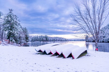 First Snow Fall Of The Year Covers Canoes On The Shore Of The Ottawa River In  Morning