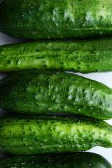 Wall Mural - Green ripe cucumbers on a white background. Delicious and juicy green vegetables.