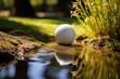Close up of a golf ball on the ground in a stream on a club course with green grass