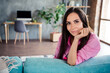 © deagreez - Photo of cheerful cute woman wear pink shirt sitting sofa smiling hand arm chin indoors apartment room