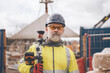 © Iryna - Closeup portrait of a Surveyor builder site engineer with theodolite total station at construction site outdoors during surveying work