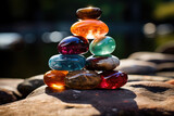 Fototapeta Londyn - Elegantly stacked glass stones in vibrant colors capturing sunlight, portraying balance and serenity in a garden setting.