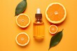 A mock-up of beauty products with a natural vitamin C serum, skincare, and essential oil in a brown glass vial with a dropper, accompanied by a fresh orange fruit slice, on an orange background.