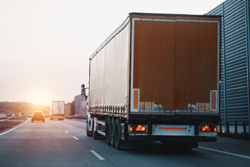 Wall Mural - Modern white semi-trailer trucks on the highway driving in the right lane. Commercial vehicle for shipping and post delivery. Shipping of the goods on land with a door-to-door delivery process.