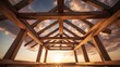 Wooden roof structure under construction with sunset background, construction site