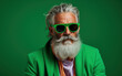 60 year old fashionable hipster man portrait on bright green background