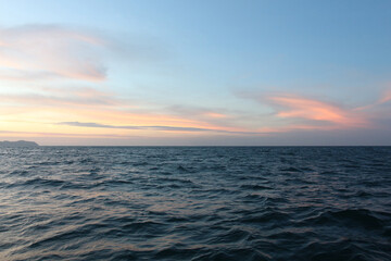 Wall Mural - Sea on a winter morning with strong winds and the rays of the morning sun on the horizon.