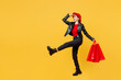 Full body young woman wear casual clothes red hat hold shopping paper package bag keep hand at forehead look far away distance go isolated on plain yellow background Black Friday sale buy day concept