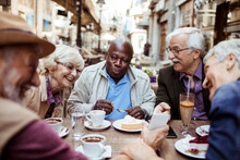 Senior Tourists Enjoying A Coffee Break In A City Cafe