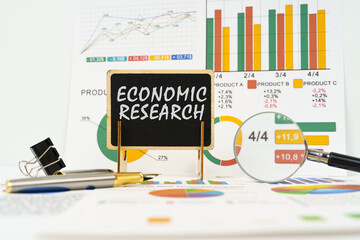 Poster - Against the background of business graphs, a board with the inscription - economic research