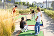 © Angelov - family playing mini golf on a cruise liner. Child having fun with active leisure on vacations.