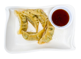 Wall Mural - Service plate containing traditional steamed Yaki Gyoza with mixed soya sauce. Isolated over white background