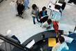 © DC Studio - Diverse people waiting in line to pay for selected clothes at department mall checkout desk top view. African american man taking shopping bag from cashier at store cash register